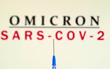 Close up of syringe with needle against background with omicron sars-cov-2 note. clipart
