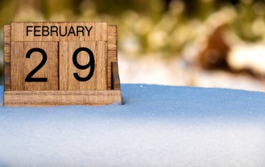 29 Şubat tarihli ahşap takvim doğada karda duruyor..