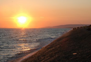 balıkçı ile sahilde günbatımı