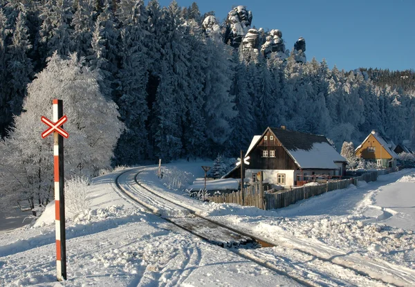 Snowy railroad crossing under the rocks