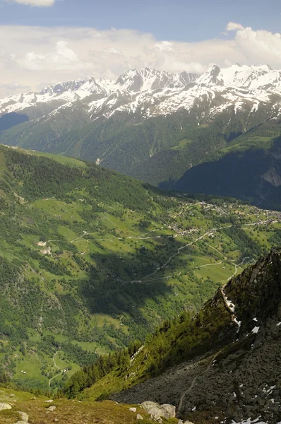 Green valley with houses and mountains — Stock Photo, Image