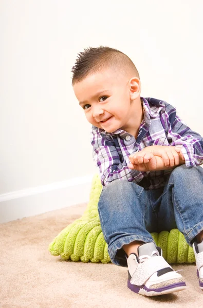 Adorável menino retrato sentado em um travesseiro — Fotografia de Stock