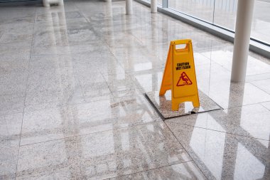 wet floor sign on lobby floor clipart