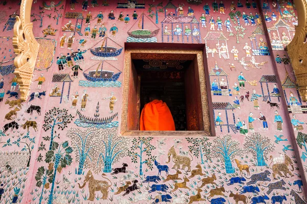 Luang Prabang, LAOS - FEB 10: A novice monk through a temple win — Stock Photo, Image