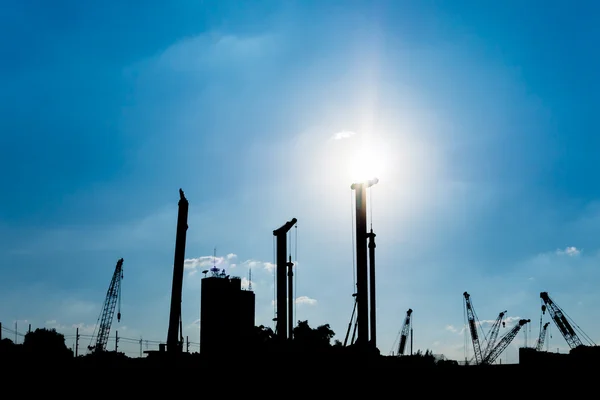 Silhueta de canteiro de obras abaixo da luz de dia de céu azul — Fotografia de Stock