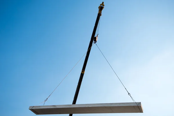 Crane lifting cement block — Stock Photo, Image