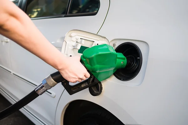 Female hand holding green pump filling gasoline — Stock Photo, Image