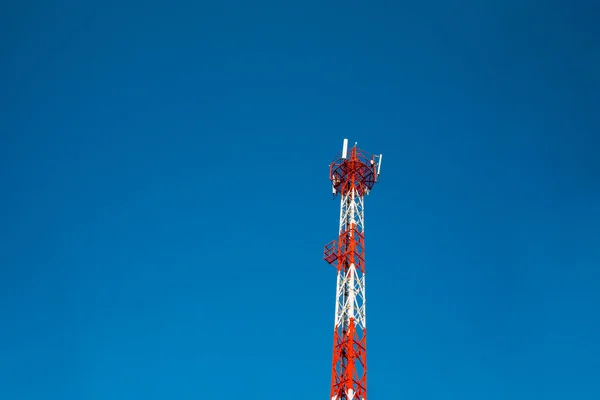En röd vit Telekommunikationen står hög under blå himmel — Stockfoto