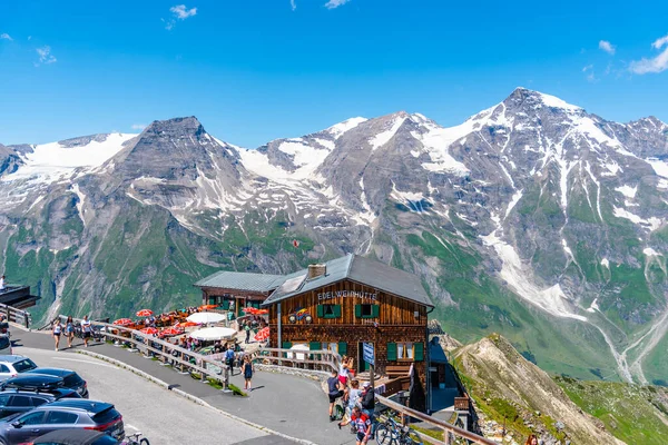 GROSSGLOCKNER HOCHALPENSTRASSE, AUSTRIA - 28 DE JULIO DE 2020: Muchas personas en Edelweisshutte - cabaña de montaña de madera cerca de la carretera alpina Grossglockner. Parque Nacional Hohe Tauern, Austria — Foto de Stock