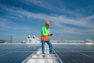 Üniforma giyen mühendis ve kask denetleme ve kontrol güneş pili paneli, güneş pili endüstriyel, alternatif çevre güç konsepti için ekoloji enerjisi güneş enerjisi kurulumu. 