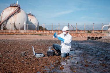 Çalışan su analizi ve su kalitesi altında koruyucu üniforma ve eldiven giyen bilim adamları laboratuvardaki vakayı kontrol etmek için atık su getirerek çevre kirliliği sorunu kavramı
