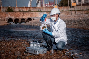 Çalışan su analizi ve su kalitesi altında koruyucu üniforma ve eldiven giyen bilim adamları laboratuvardaki vakayı kontrol etmek için atık su getirerek çevre kirliliği sorunu kavramı