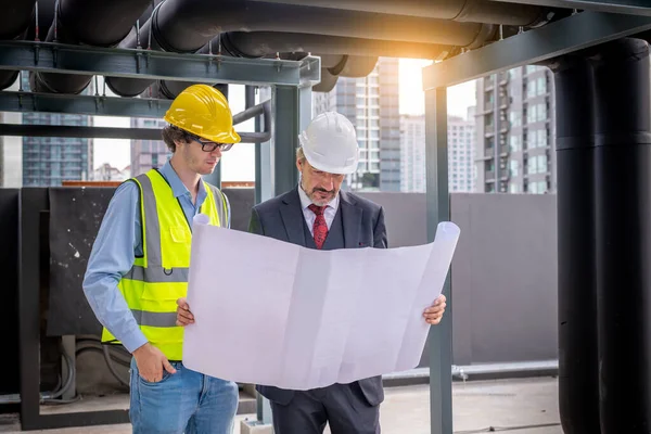 Industry engineer under checking the industry cooling tower air conditioner is water cooling tower air chiller HVAC of large industrial building to control air system.