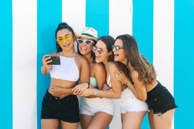 four friends taking a self portrait at the beach