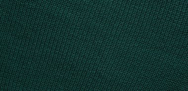 Düz örülmüş koyu yeşil süveter desenli. Üst manzara, yakın plan. El yapımı yün ya da pamuk kumaş dokusu. Büyük kaburgaların arka planı örgü iğneleri ya da örgü örgüleriyle örülmüş..