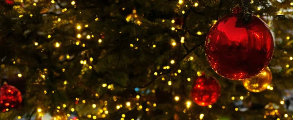 Banner de Natal com espaço de cópia e brilhos para cartão de saudação. Ramo de abeto com bolas vermelhas, luzes amarelas festivas e bokeh. Conteúdo perfeito para banners publicitários, cartões de presente ou projetos criativos. — Fotografia de Stock