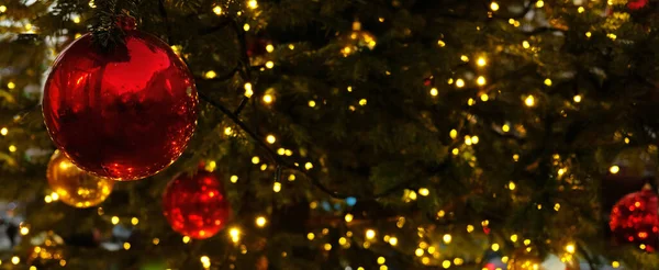 Banner de Natal com espaço de cópia e brilhos para cartão de saudação. Ramo de abeto com bolas vermelhas, luzes amarelas festivas e bokeh. Conteúdo perfeito para banners publicitários, cartões de presente ou projetos criativos. — Fotografia de Stock
