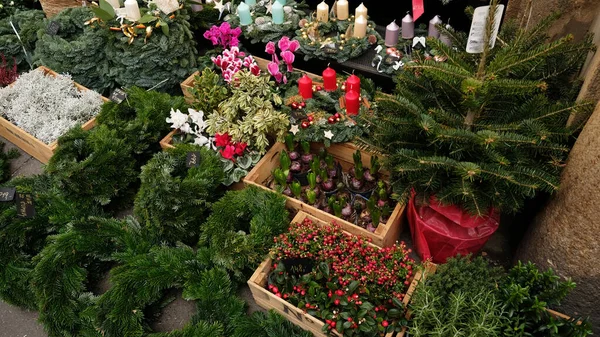 Marktkraam met items voor Kerstmis - sparren krans, adventskaarsen, kerstboom decoraties. Kerstkrans met kaarsen voor de komst. — Stockfoto