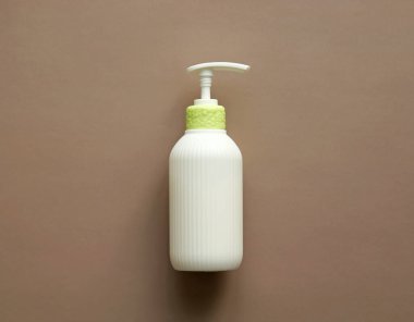 White corrugated bottle surface soap dispenser pump. Skin care Lotion. Bathing essential product. Shampoo bottle. Mock-up pump bottle of moisturizing lotion, soap, or sanitizer on beige background. 
