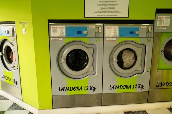 공공자기 서비스 세탁소 내부의 녹색 부분. 동전으로 작동하는 빨래방 세탁기. 스페인 안달 루시아, 말라가 주의 세탁소에 있는 산업용 세탁기들 — 스톡 사진