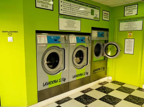 공공자기 서비스 세탁소 내부의 녹색 부분. 동전으로 작동하는 빨래방 세탁기. 스페인 안달 루시아 주 말 라가 주의 세탁소에 있는 산업용 세탁기들, 2022 년 1 월 - 1 월. — 스톡 사진