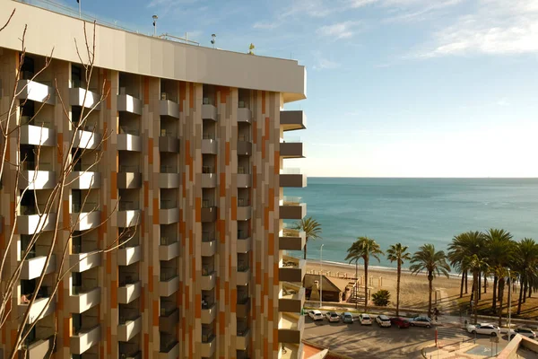 Letecký pohled na resort hotel nebo bytový dům s balkony v Torremolinos, Španělsko - leden,2022. Pohled na písečnou pláž a datlové palmy na pozadí modrého moře, horizont. — Stock fotografie