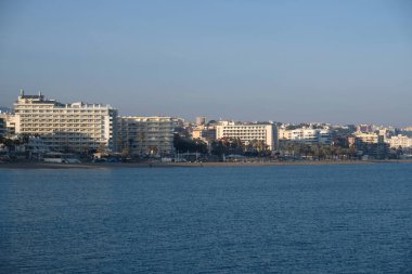 Malaga, Endülüs, İspanya 'daki Akdeniz kıyısındaki yüksek binalar ve otellerin manzarası. Kumsal manzarası, palmiye ağaçları, mavi deniz, mavi gökyüzü ve dağlar. Emlak kavramı.