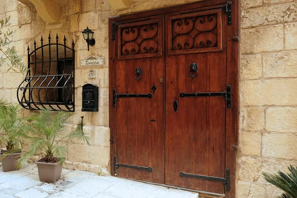 Traditional vintage painted wooden door in Malta. Popular travel destination. Entrance to house. Exterior of typical houses on the Mediterranean island of Malta - April, 2022.