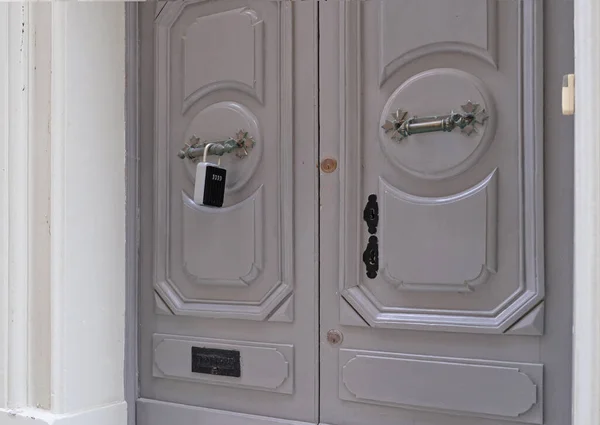 Smart key lock mounted on a gray door for renting apartment. Safe Key Box is used when the guest arrives at the touristic flat and the host can\'t open the door. Safe access to living space.