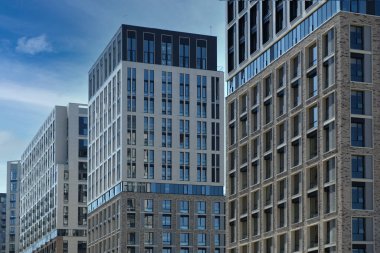 Exterior of a modern building house object with texture walls and windows. Luxury modern tall block of flats without balconies. Living apartments or office building. Real estate concept.