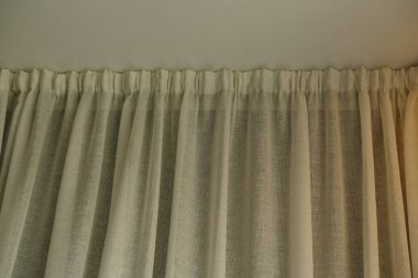 Close-up Cornice with drapes and white curtain or tulle. White wall, ceiling, cornice niche, curtains on the window. Corner hidden curtain rod. Interior details close up. 