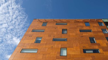 Modern kahverengi ev nesnesinin dışı. Bir gökdelenin mimari ayrıntıları, pencerelere yakın çekim. Gayrimenkul, apartman daireleri ve ofisler. Yaşayan daireler ya da ofis mimarisi