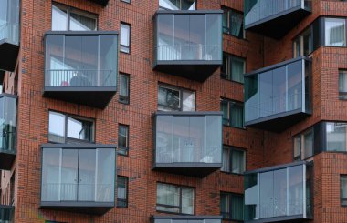 Modern kırmızı tuğlalı evin dışı. Pencerelere, balkonlara yakın planların mimari ayrıntıları. Gayrimenkul, apartman daireleri ve ofisler. Yaşayan daireler ya da ofis mimarisi.