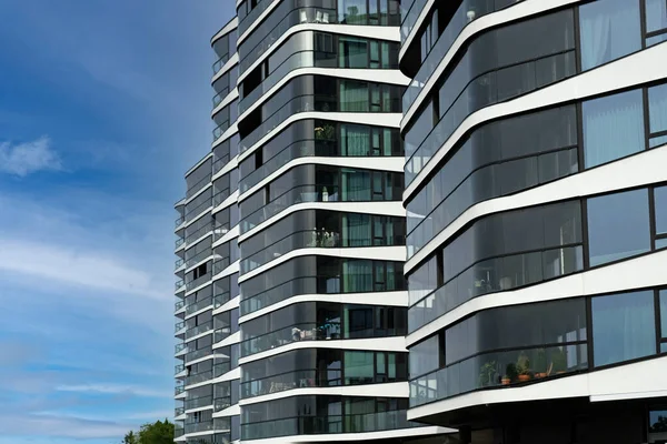 Exterior of modern glass house. Architectural detail of skyscraper, close-up on windows, balconies. Real estate, residential apartments and offices. Living apartments or office building architecture.