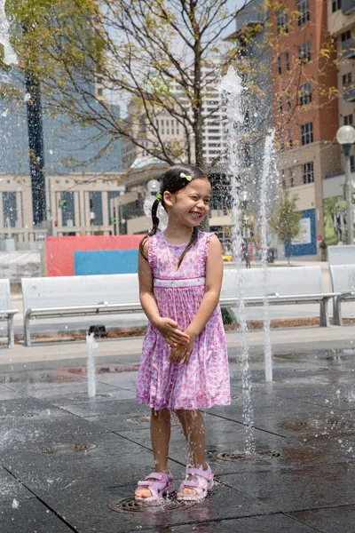 Ung flicka på en splash fontän — Stockfoto