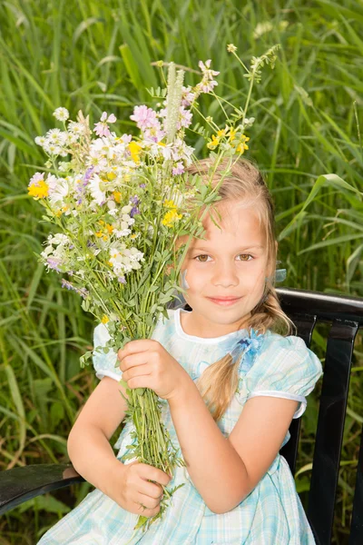 Jong meisje met wilde bloemen — Stockfoto