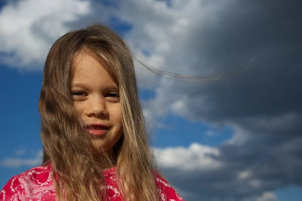 Gelukkig jong meisje tegen bewolkte hemel — Stockfoto