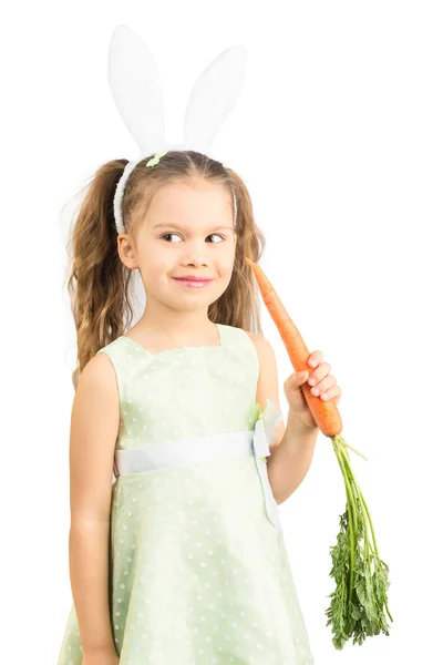 Niña en orejas de conejo sosteniendo zanahoria — Foto de Stock