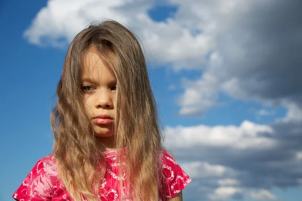 Niña molesta contra cielo nublado —  Fotos de Stock