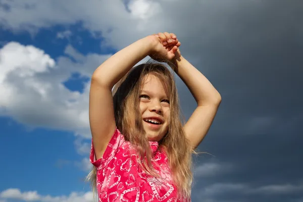 Nadšený mladá dívka proti zatažené obloze — Stock fotografie