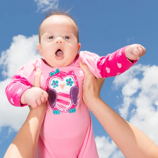 Kis baba lány ellen felhős ég — Stock Fotó