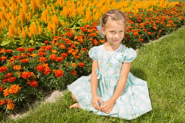 Flicka nära blomsterrabatt — Stockfoto