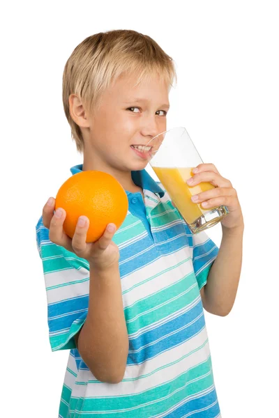 Menino em idade escolar segura um copo com um suco de laranja com uma mão — Fotografia de Stock