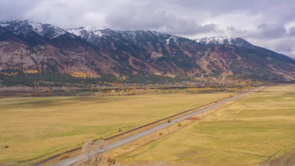 秋の曇りの日にテトン範囲、牧草地、道路。アメリカのワイオミング州。空中展望 — ストック動画