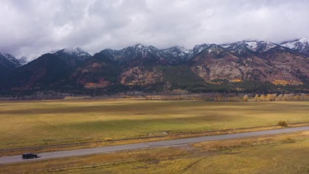 Teton Range, Meadow and Road op herfstbewolkte dag. Wyoming, Verenigde Staten Luchtzicht — Stockvideo