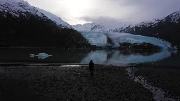 O homem caminha em direcção ao Glaciar Portage. Alaska, EUA. Vista aérea — Vídeo de Stock