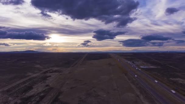 Bilar på motorvägen vid solnedgången. Wyoming, USA. Flygvy — Stockvideo