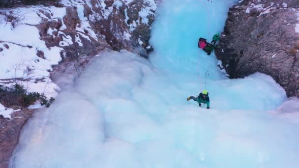 男は氷の上を進んでいる。凍った滝の氷のクライミング — ストック動画