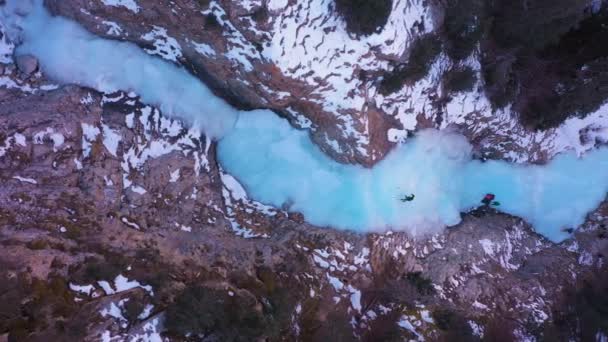 Człowiek prowadzi na lodzie. Wspinaczka po zamarzniętym wodospadzie — Wideo stockowe