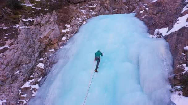 Muž vede na Ice. Lezání po zamrzlém vodopádu — Stock video